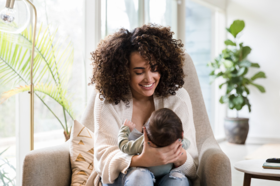 A parent playing with a newborn.