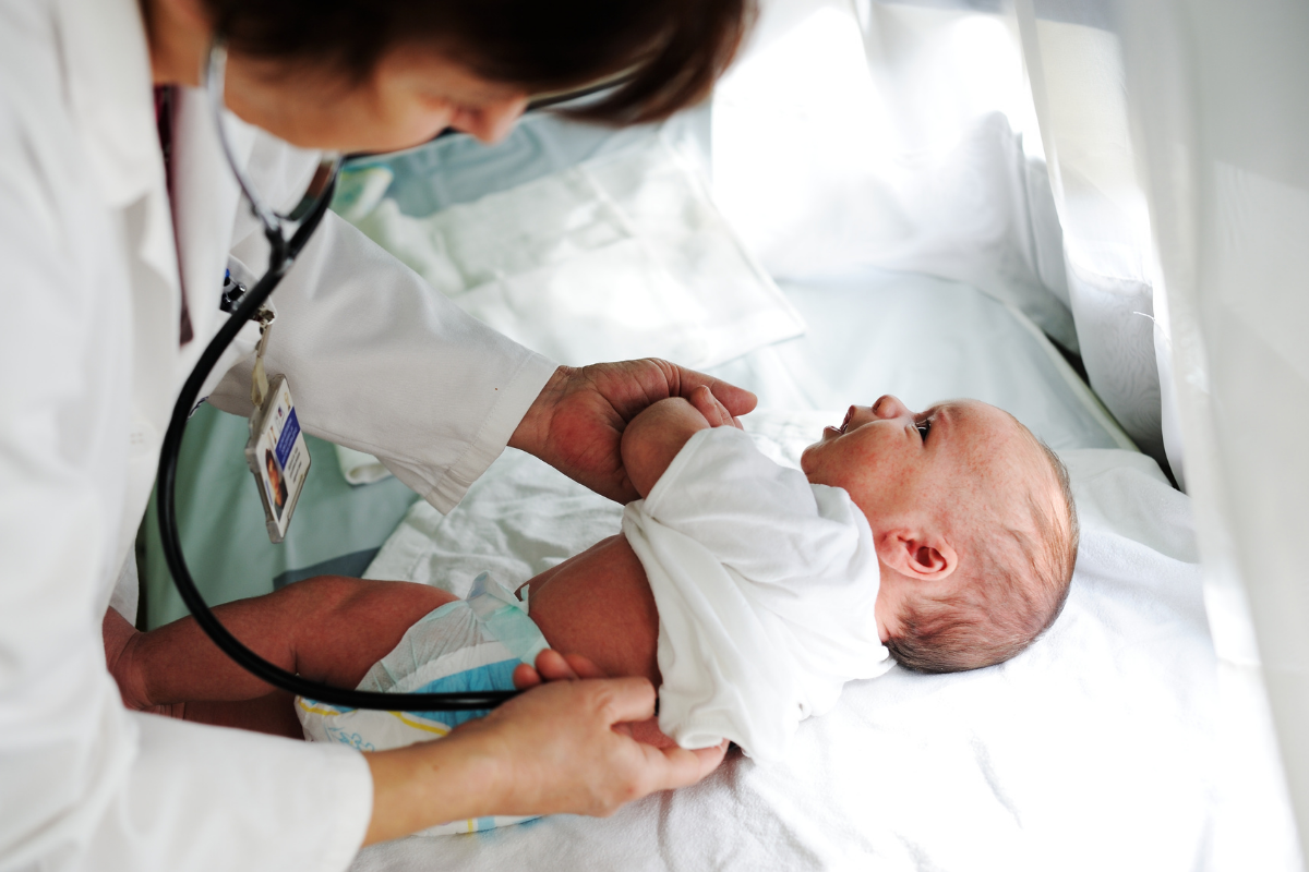 A doctor checking a new born.