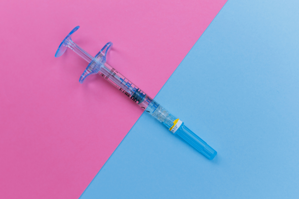 An injection in a blue and pink background.