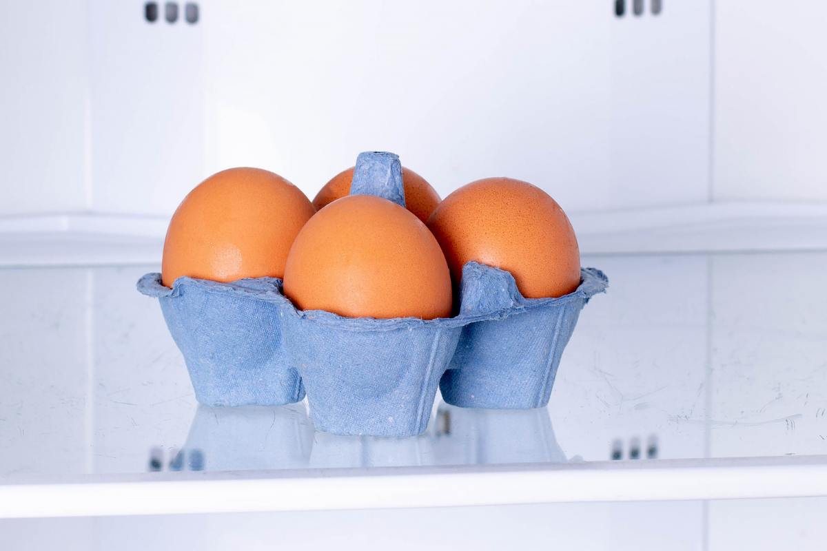 A basket  of eggs in a freezer.