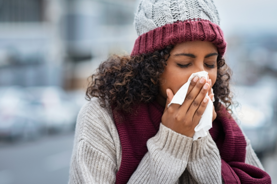 A person sneezing in cold weather.