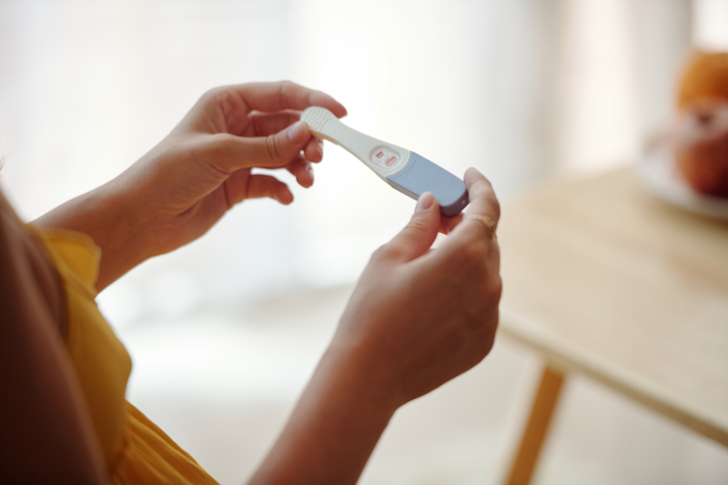 A person looking at a pregnancy test.