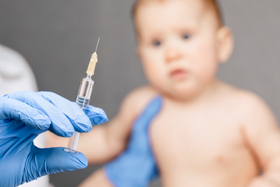 A baby about to take a vaccine shot.
