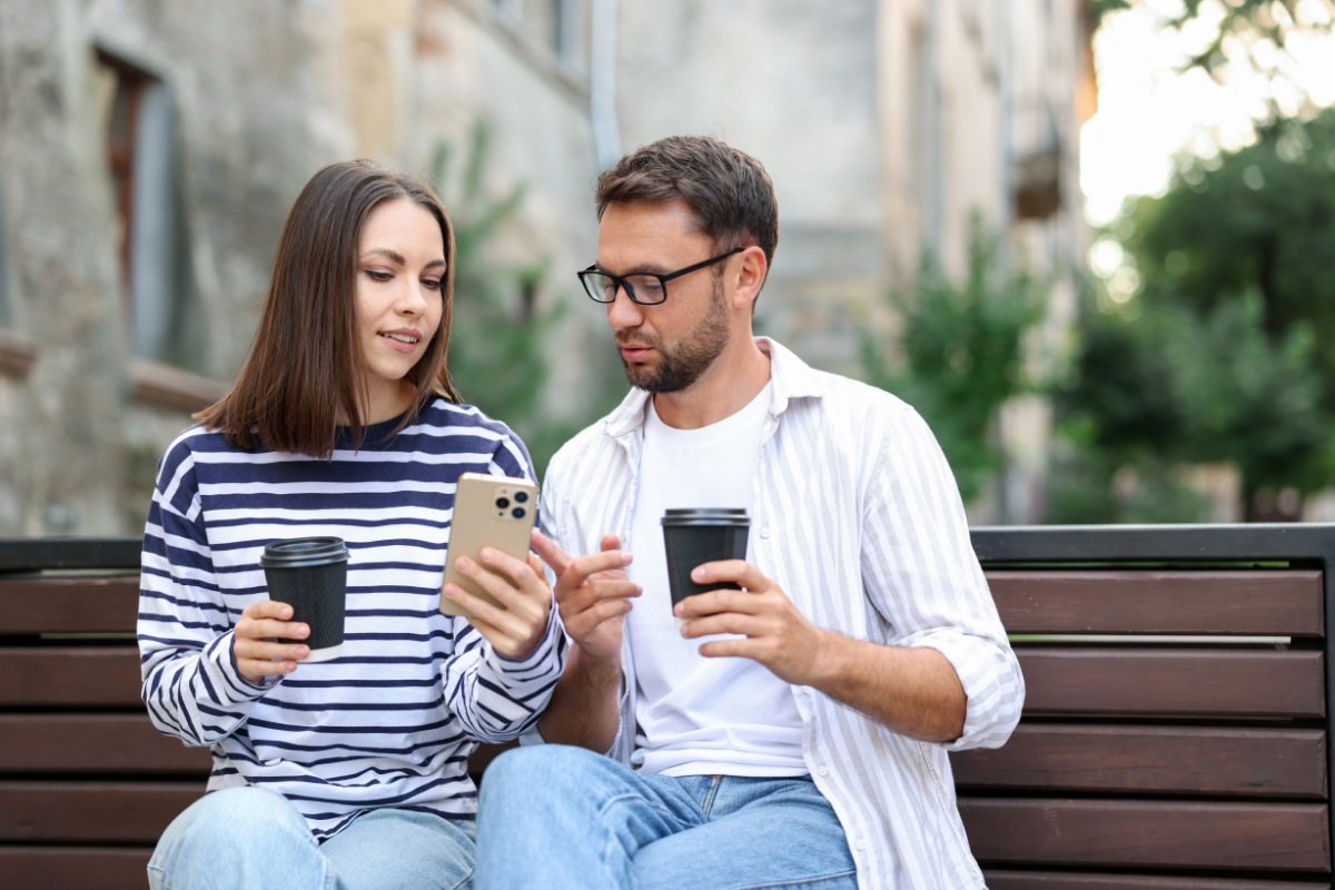 A couple looking at their phones and discussing.