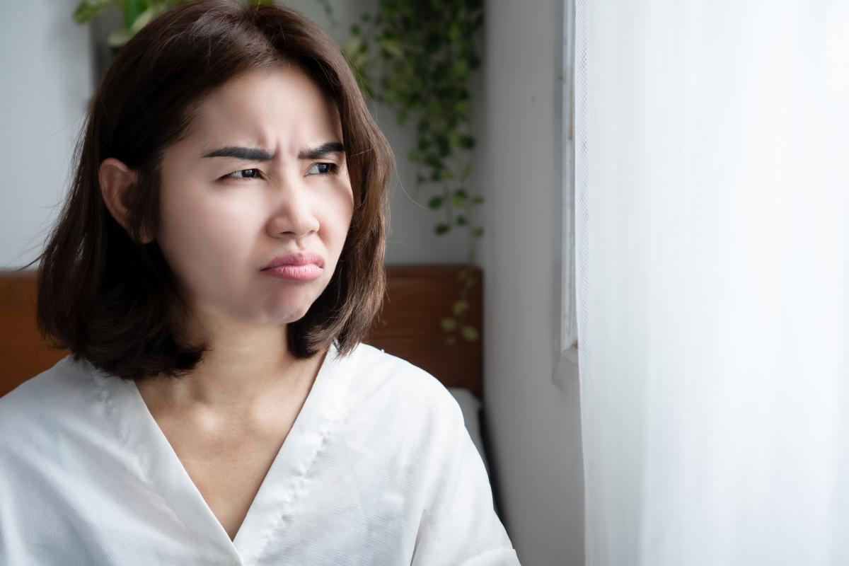 A person looking out the window looking stressed.