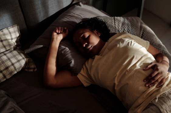 A pregnant person sleeping.