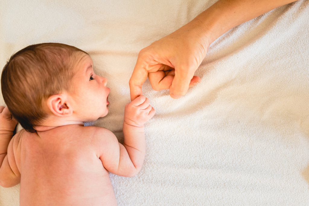Baby holding mom's finger