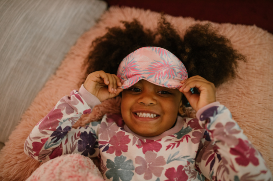Little girl lying awake with eye mask on