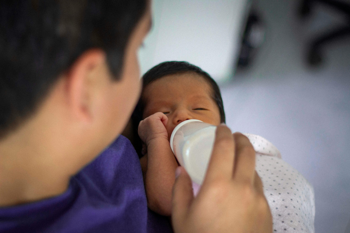 Parenting feeding a newborn a bottle of formula